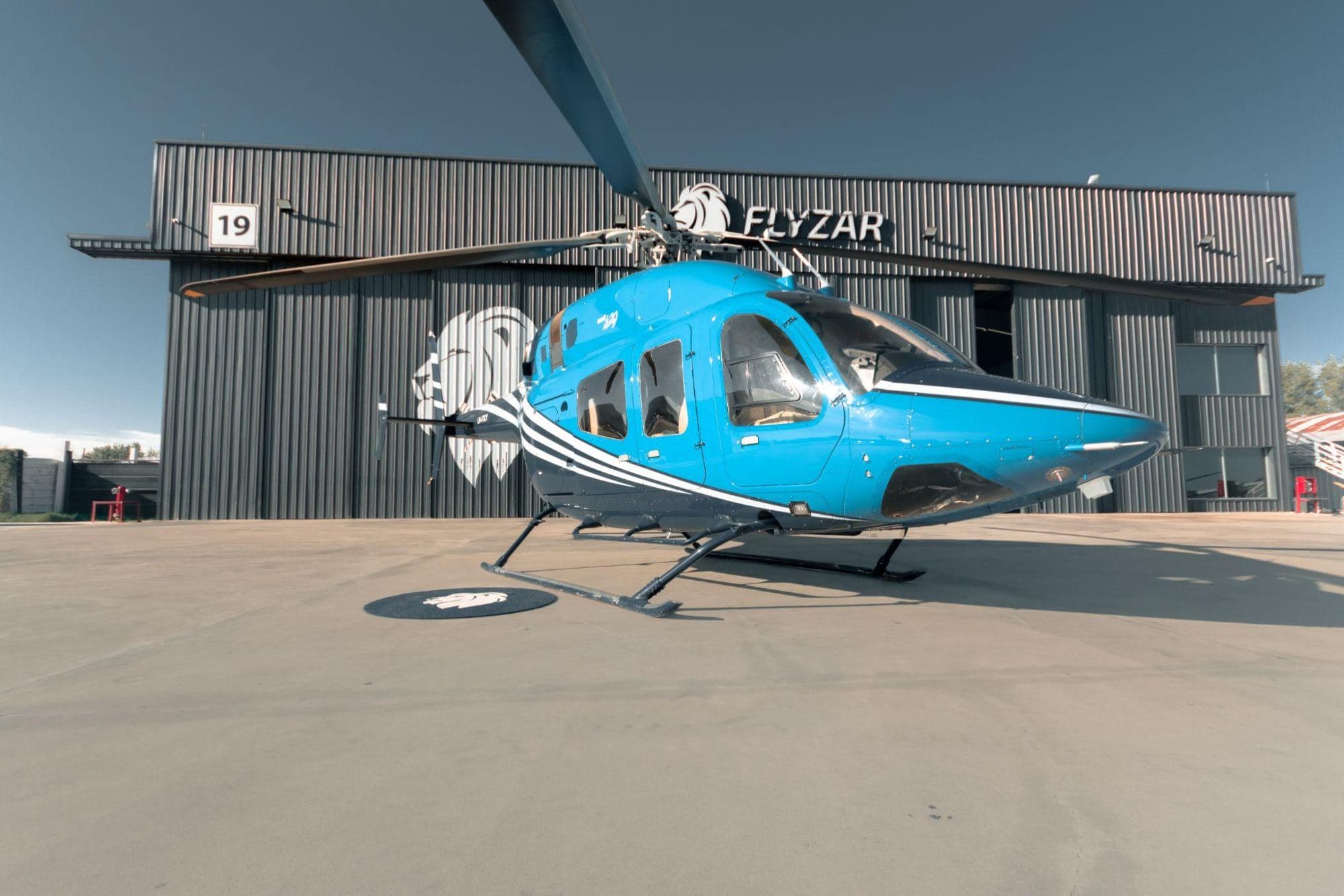 Helicóptero Bell 429 LV-FKY frente al hangar de Flyzar