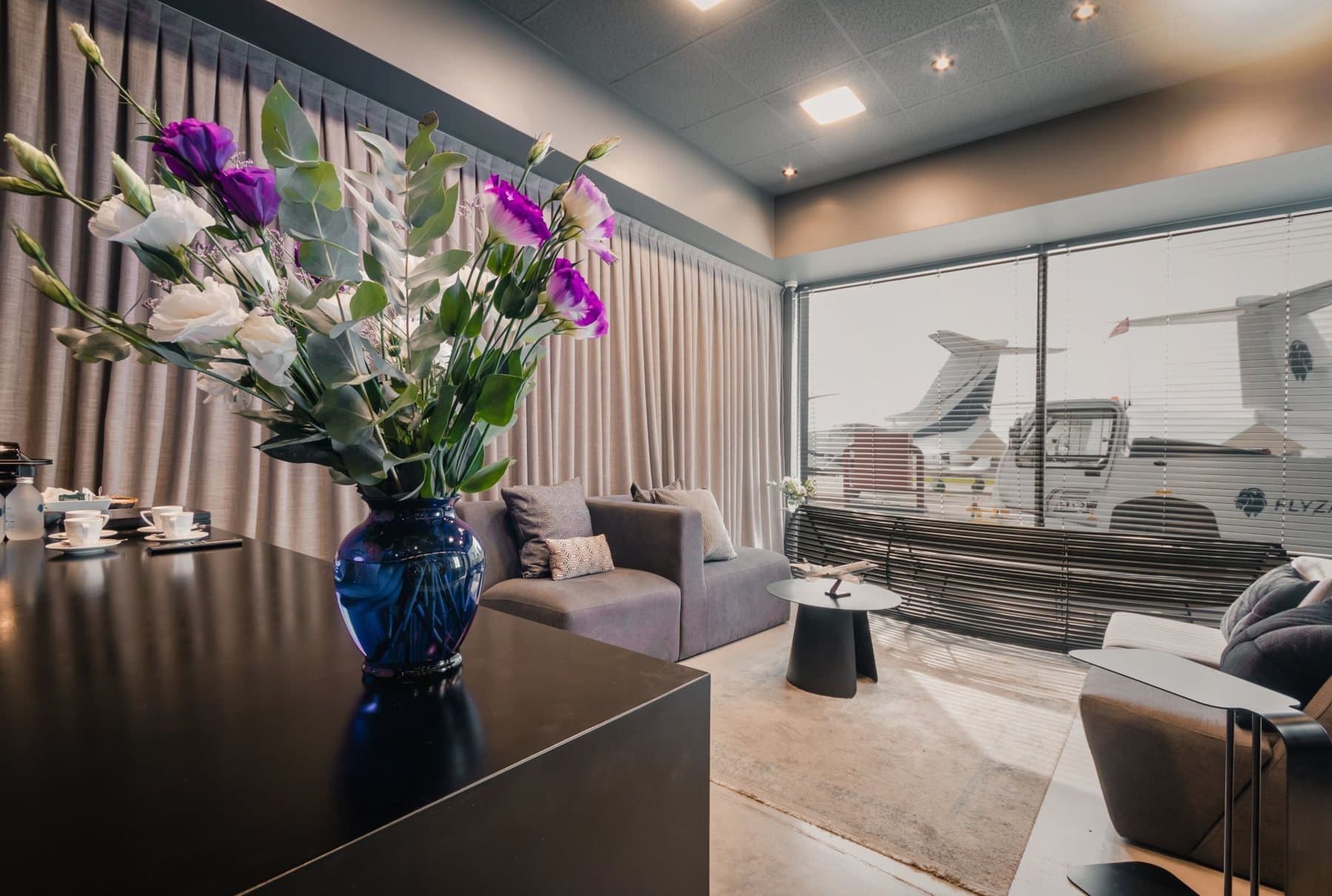 Sala VIP del FBO con flores, sillones y vista a la plataforma