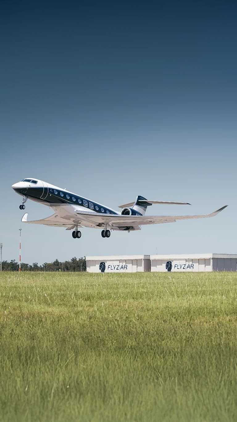 Jet privado despegando sobre el pasto del aeródromo